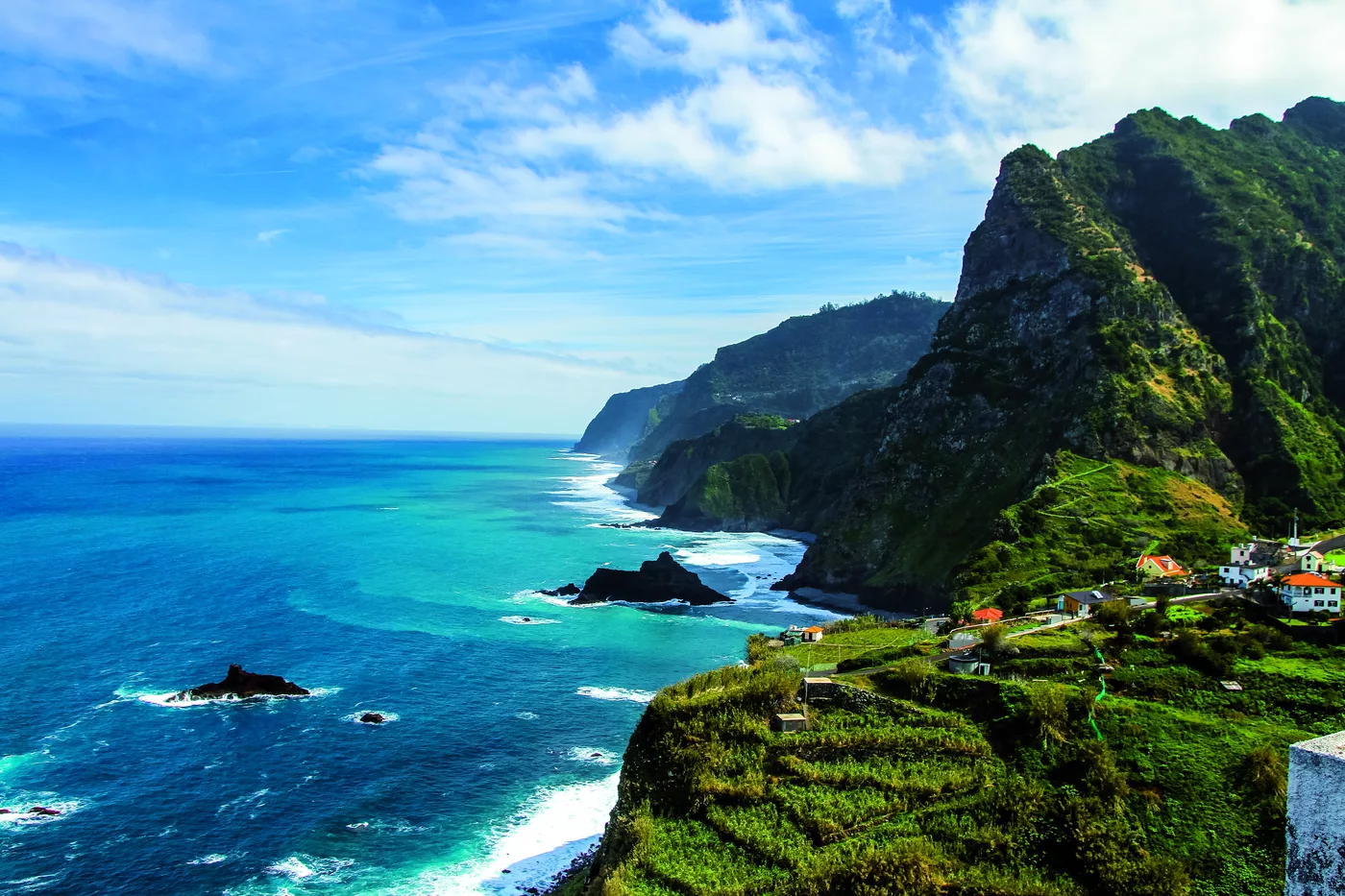 Türkisfarbene Bucht mit Felsnadeln vor grün bewachsenen Klippen Türkisfarbene Bucht mit Felsnadeln vor grün bewachsenen Klippen