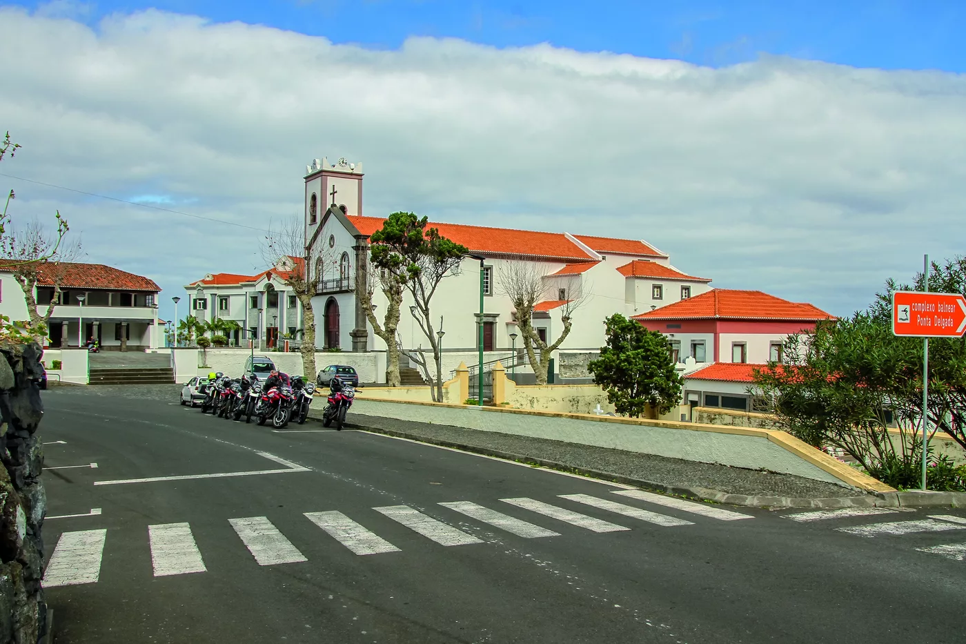 Motorräder auf der Hauptstraße eines Dorfes mit weißer Kirche Motorräder auf der Hauptstraße eines Dorfes mit weißer Kirche