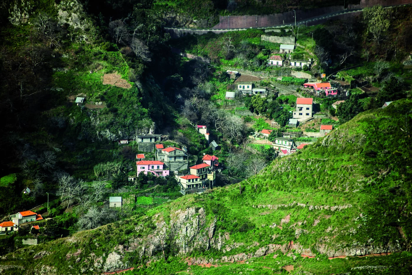 Terrassenfelder und verstreute Häuser in einem tief eingeschnittenen Tal